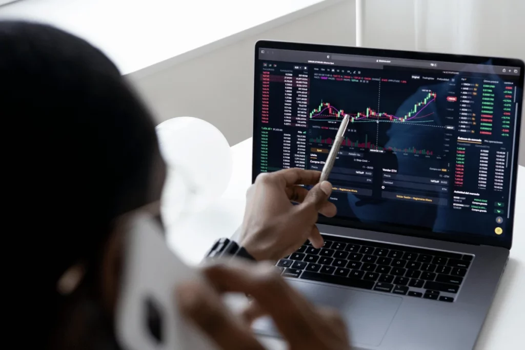Person analyzing stock market graphs on a laptop screen.