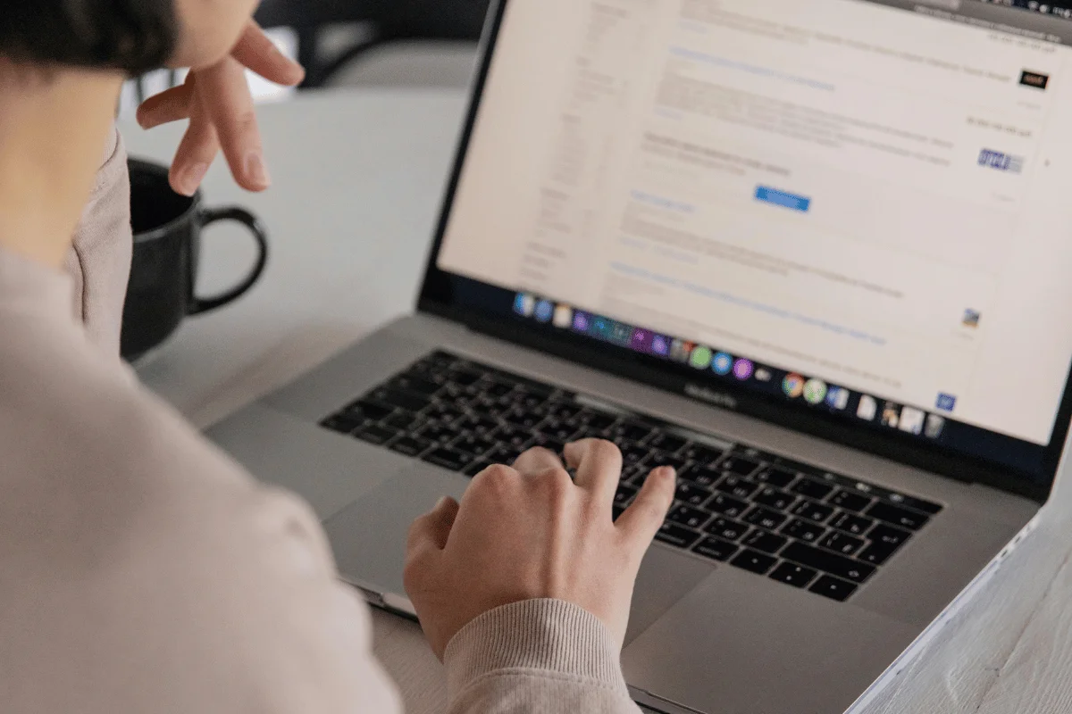 Person working on a laptop, browsing search engine results for an SEO company.